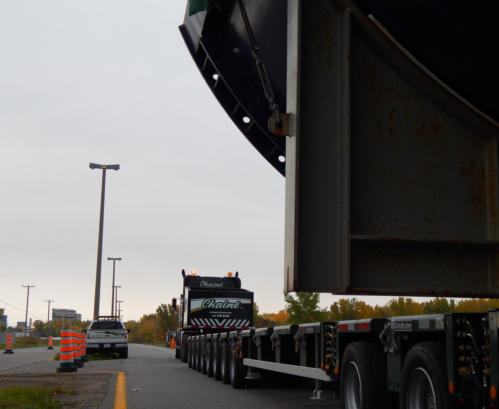 La pièce soulevée au-dessus du rail de glissage hydraulique posé sur la chaussée, le transporteur vide derrière